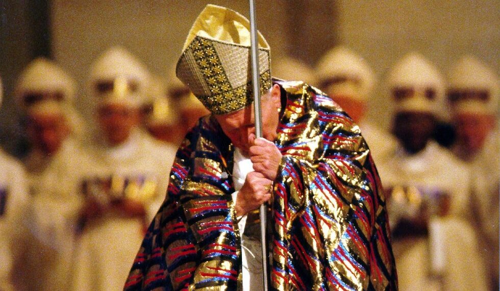 Papa Giovanni Paolo II in ginocchio dopo l'apertura della Porta Santa, che indica l'inizio dell'anno del Giubileo, 24 dicembre 1999 (ANSA)